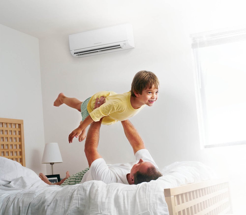 boy in air with dad on bed